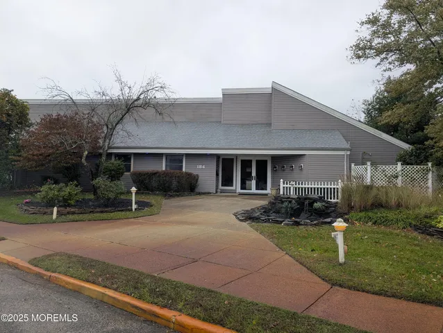 a sign of golf club on a wall under a tree