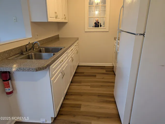 a kitchen with a refrigerator sink and cabinets
