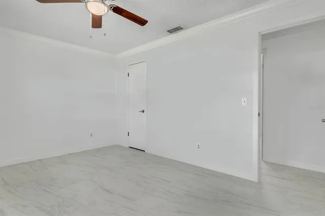 an empty room with a ceiling fan and window