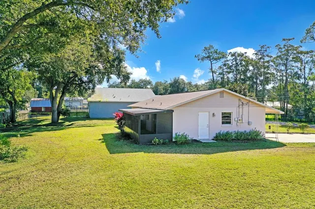 a view of a house with pool and a yard