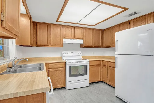 a kitchen with a white stove top oven and refrigerator