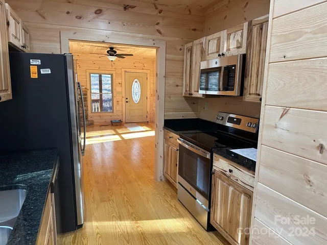 a kitchen with granite countertop a sink and a refrigerator