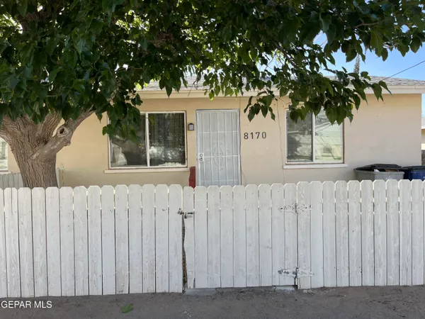 a view of a house with wooden fence
