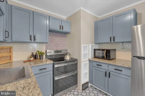 a kitchen with cabinets appliances and a counter space