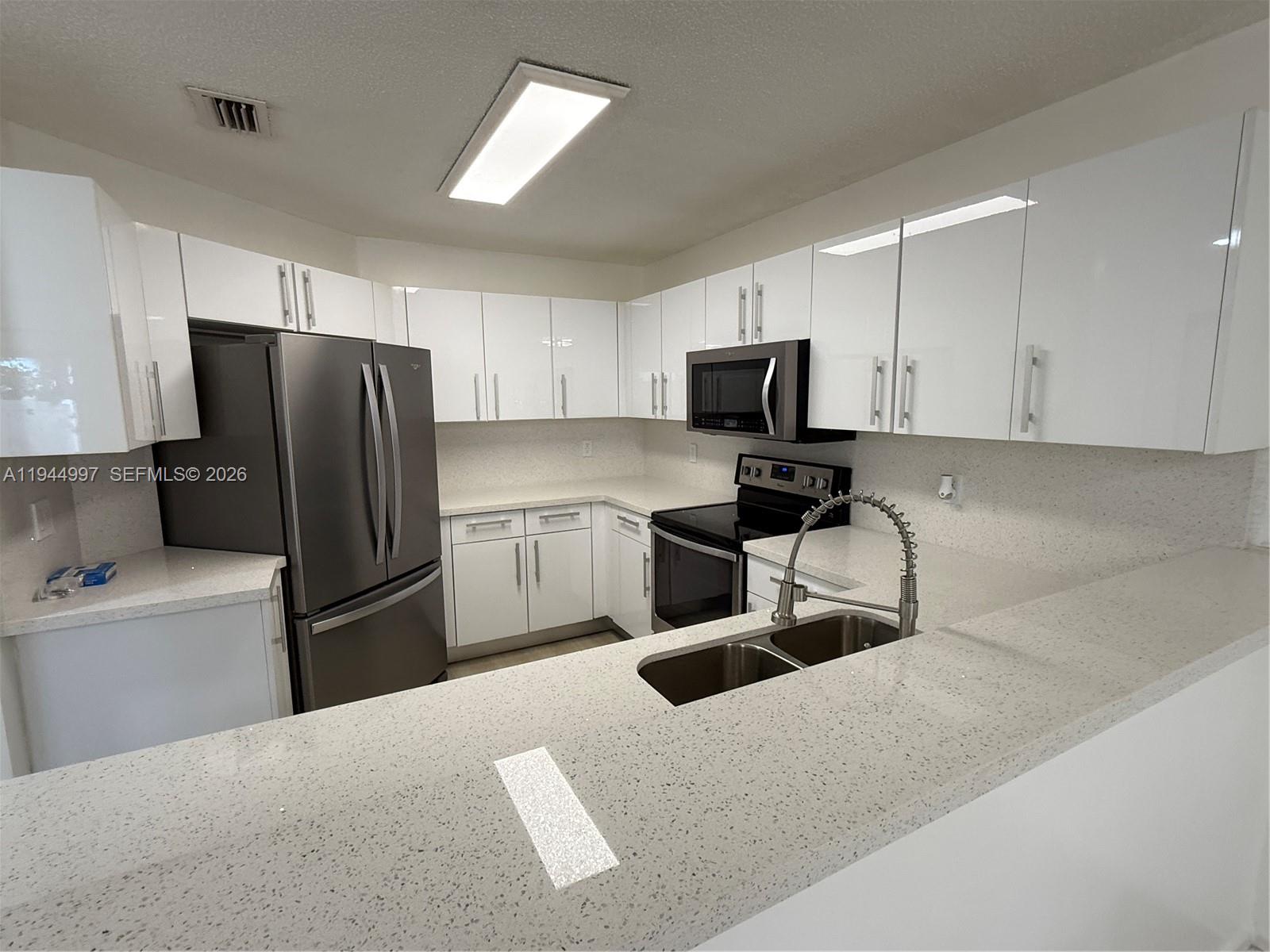 a kitchen with stainless steel appliances granite countertop a refrigerator and a sink