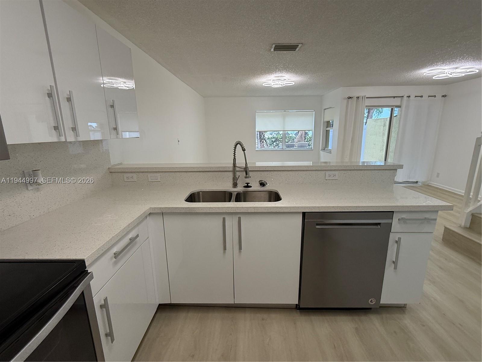 973 Imperial Lake Road, Unit 973 West Palm Beach, FL 33413 - Photo 14 of 28 a kitchen with sink cabinets and wooden floor