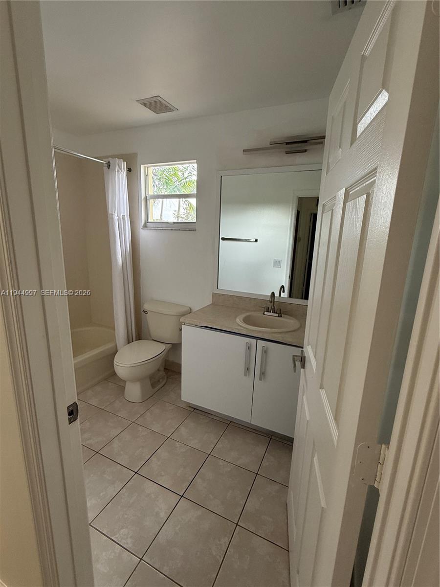 973 Imperial Lake Road, Unit 973 West Palm Beach, FL 33413 - Photo 15 of 28 a bathroom with a sink a toilet and a mirror