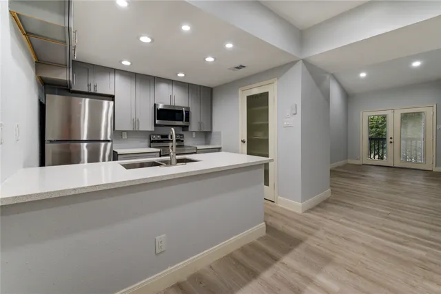 an empty room with wooden floor and a ceiling fan
