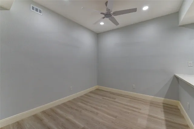 an empty room with a ceiling fan and carpet