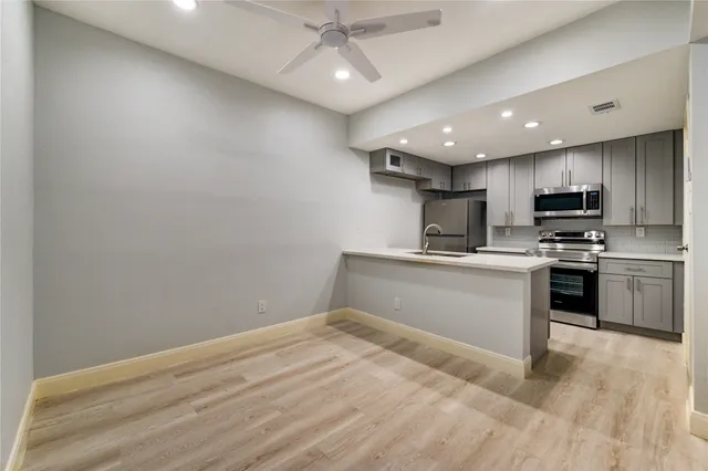 a kitchen with stainless steel appliances granite countertop a refrigerator and a stove top oven