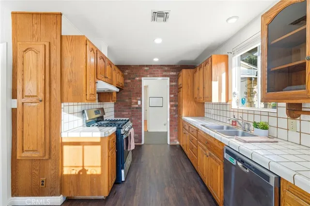 a kitchen with stainless steel appliances granite countertop a stove a sink and a refrigerator