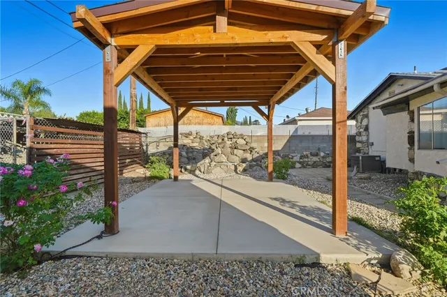 a backyard of a house with table and chairs under an umbrella