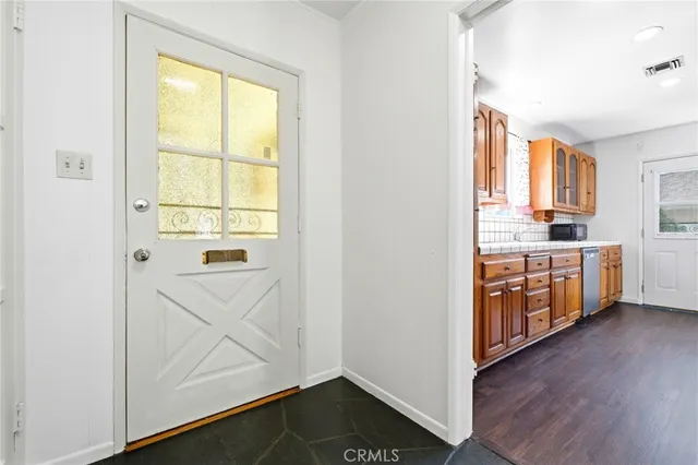 a view of a kitchen with wooden floor and a window