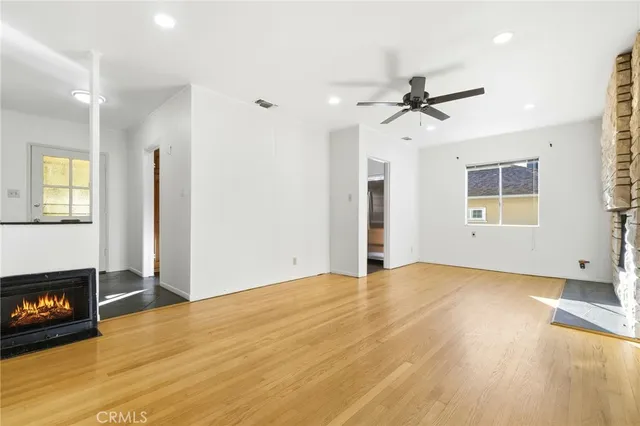 a view of empty room with wooden floor and fireplace