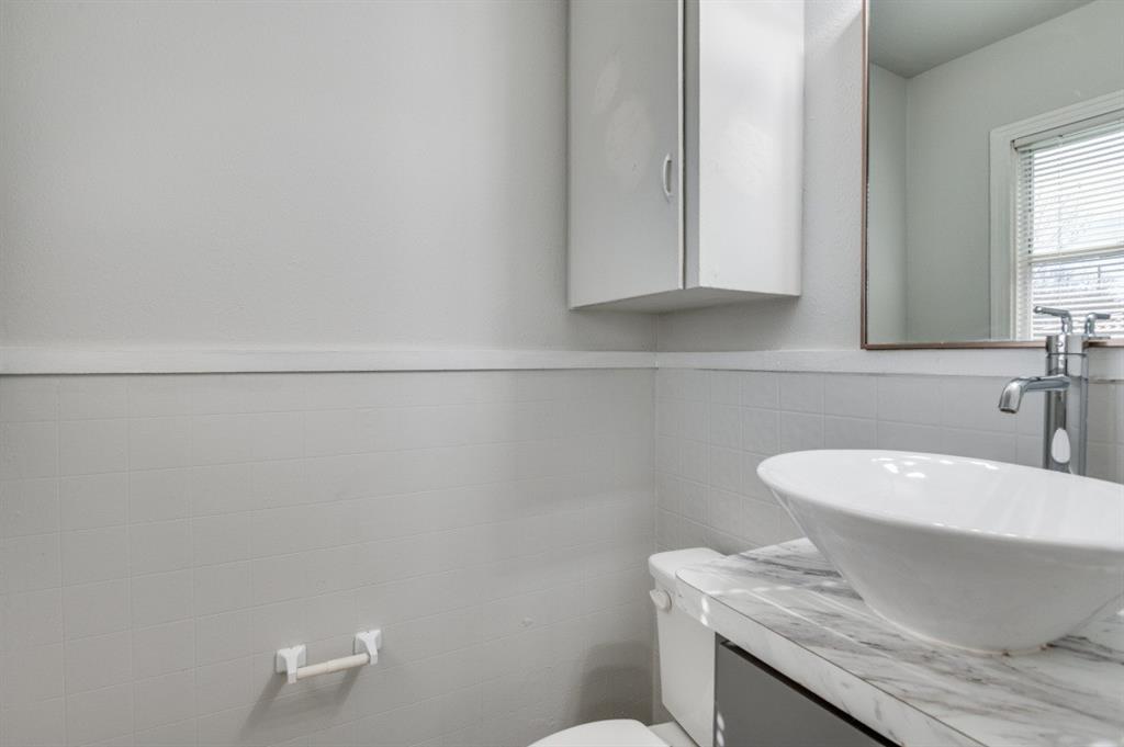 4412 Utah Avenue Dallas, TX 75216 - Photo 10 of 11 a bathroom with a toilet a sink and mirror