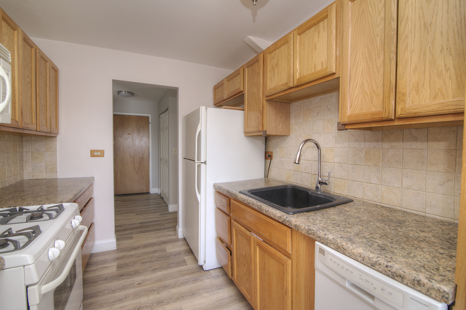 1301 South Finley Road, Unit 204 Lombard, IL 60148 - Photo 13 of 24 a kitchen with granite countertop a sink stove and refrigerator