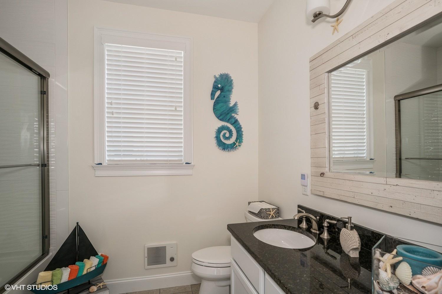 61 Old Wharf Road, Unit 62 Dennis Port, MA 02639 - Photo 13 of 25 a bathroom with a sink a toilet and a window