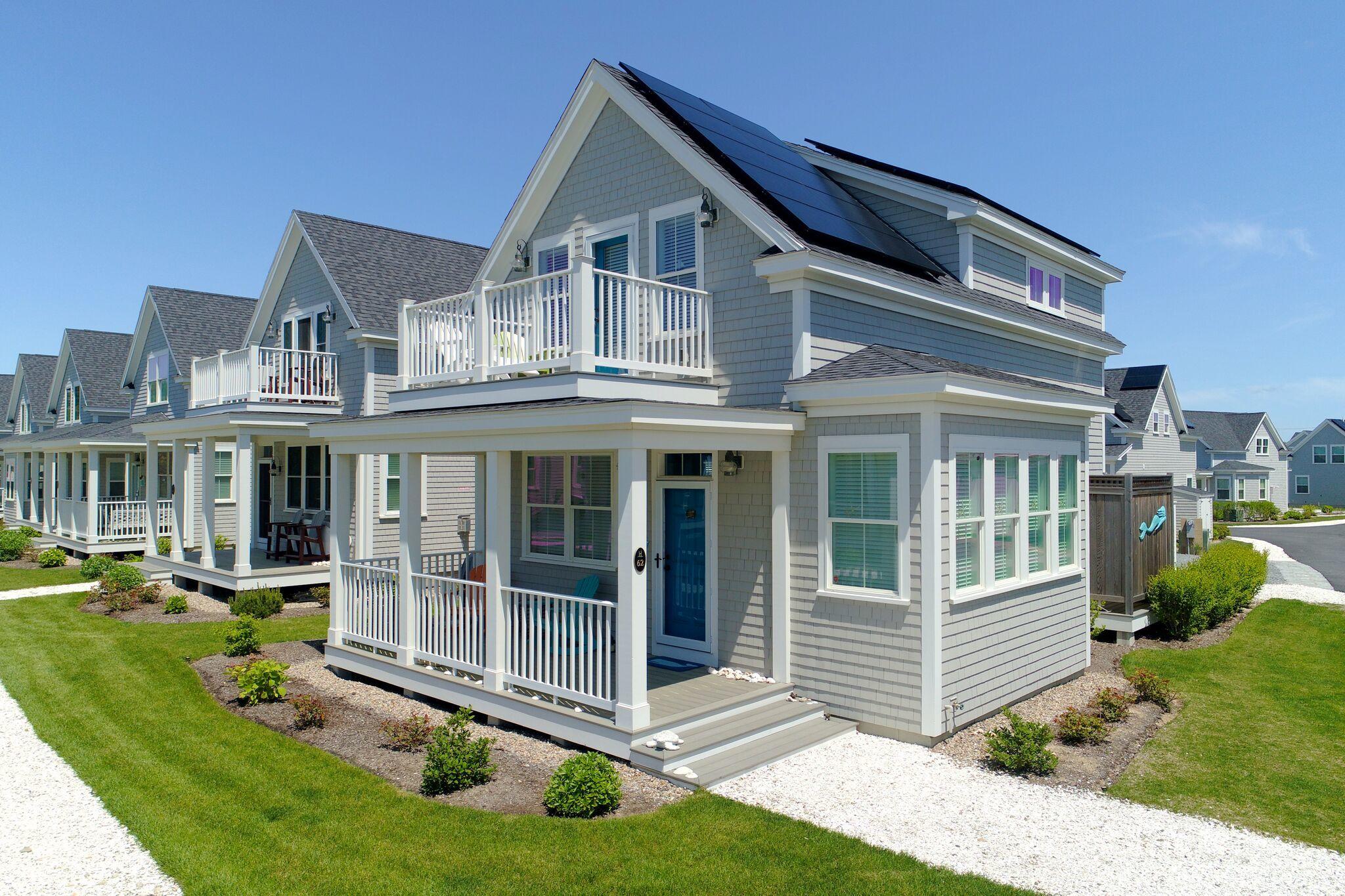 61 Old Wharf Road, Unit 62 Dennis Port, MA 02639 - Photo 5 of 25 a front view of a house with a yard table and chairs