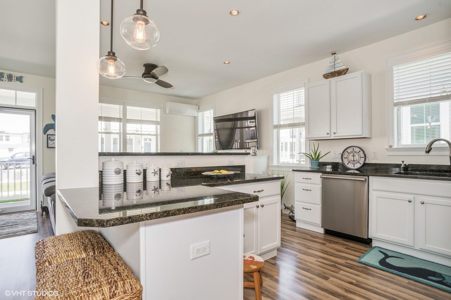 61 Old Wharf Road, Unit 62 Dennis Port, MA 02639 - Photo 10 of 25 a kitchen with granite countertop lots of white cabinets and stainless steel appliances