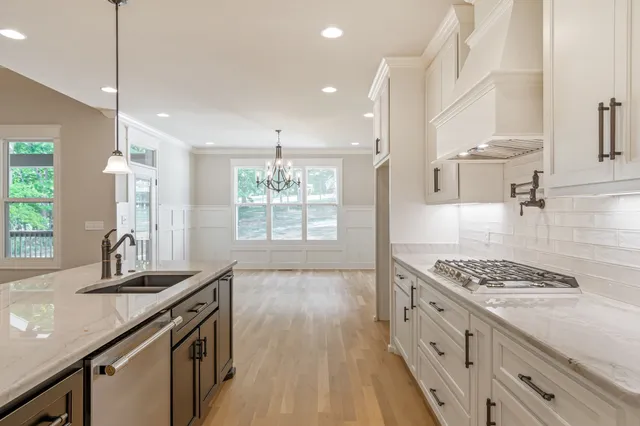 a bathroom with a granite countertop toilet a sink a mirror and bathtub