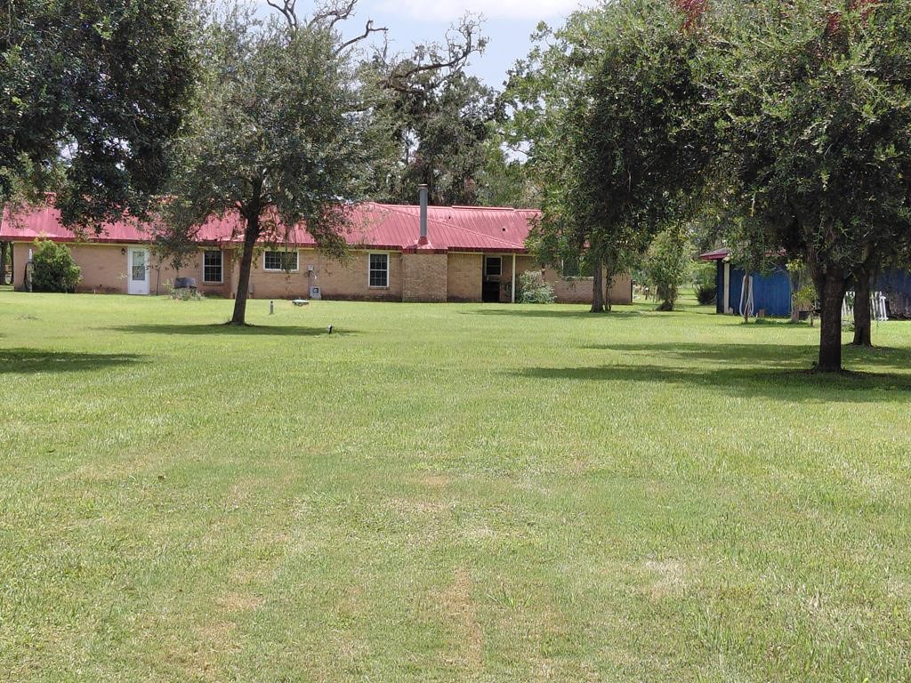 1231 County Road 201A Angleton, TX 77515 - Photo 12 of 26 a front view of a house with a yard and tree