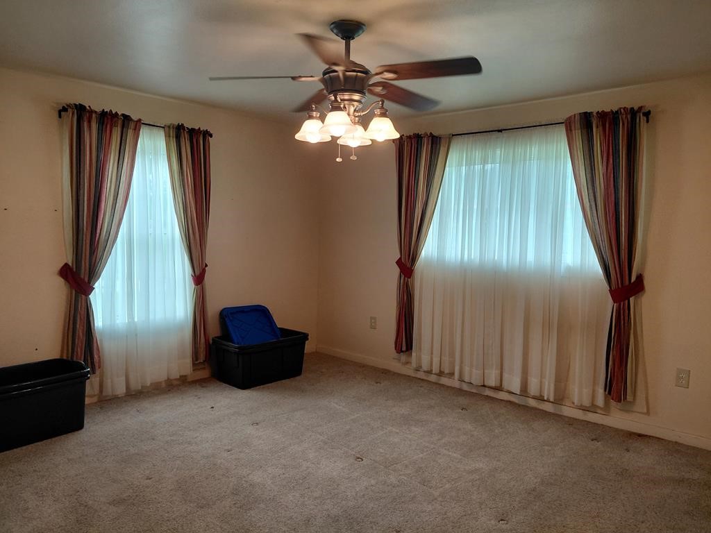 1231 County Road 201A Angleton, TX 77515 - Photo 14 of 26 an empty room with windows and ceiling fan