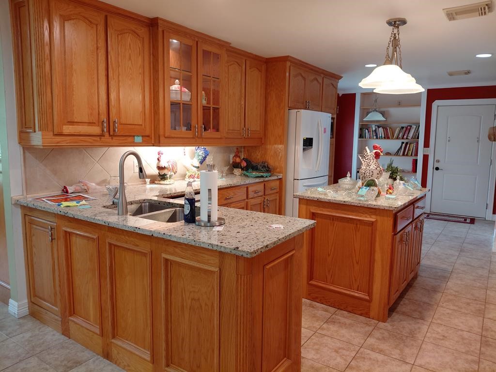 1231 County Road 201A Angleton, TX 77515 - Photo 17 of 26 a kitchen with stainless steel appliances granite countertop a sink dishwasher stove and refrigerator with wooden cabinets