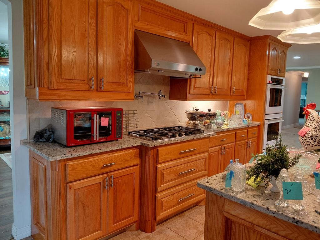 1231 County Road 201A Angleton, TX 77515 - Photo 19 of 26 a kitchen with stainless steel appliances granite countertop a sink stove and cabinets