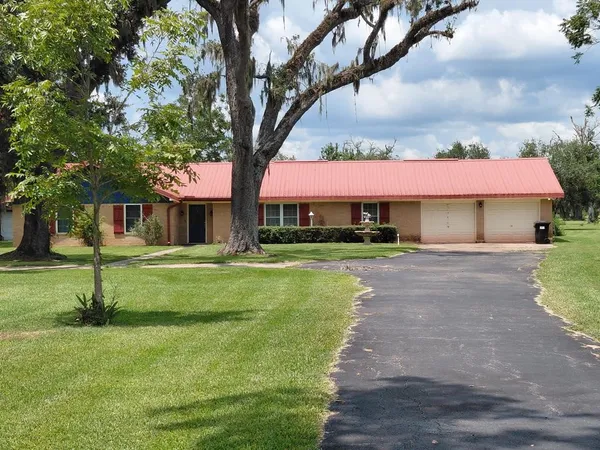 a front view of a house with yard and green space