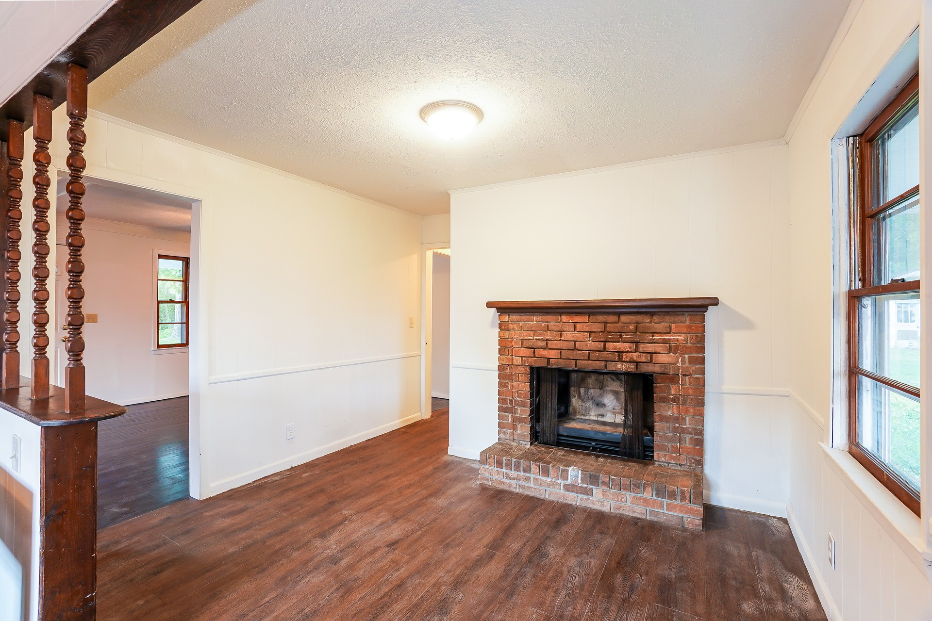 231 Foston Chapel Road Hopkinsville, KY 42240 - Photo 17 of 20 a view of an empty room with wooden floor fireplace and a window