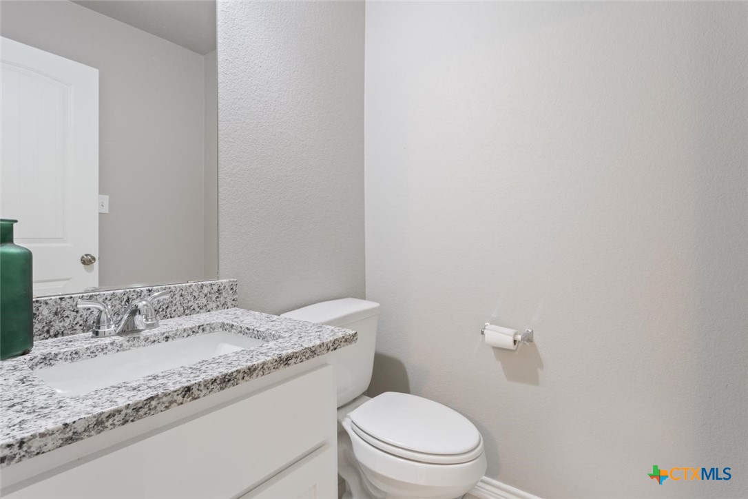 907 East Main Street, Unit A&B Troy, TX 76579 - Photo 26 of 28 a bathroom with a granite countertop sink mirror vanity and toilet