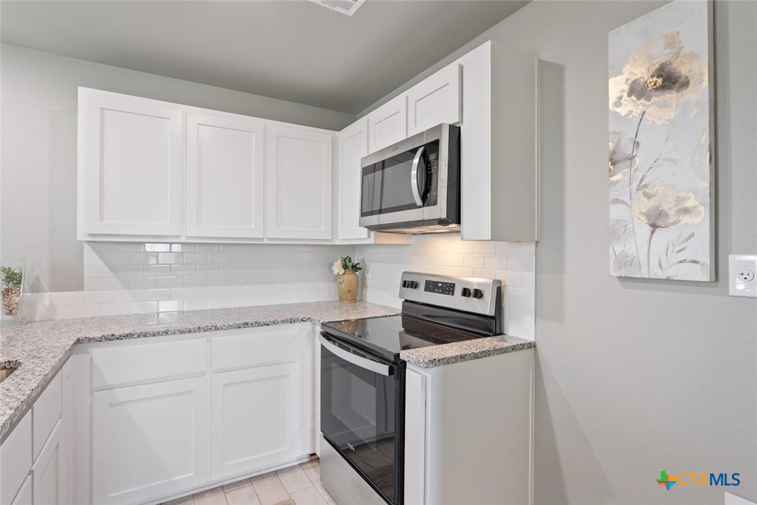 907 East Main Street, Unit A&B Troy, TX 76579 - Photo 10 of 28 a kitchen with granite countertop white cabinets and white appliances
