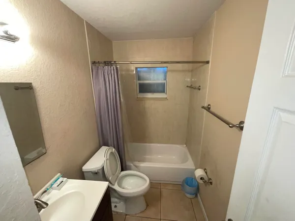 a bathroom with a granite countertop toilet sink and mirror