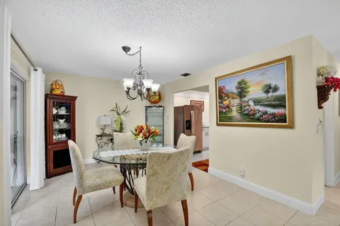a view of a dining room with furniture a chandelier and wooden floor