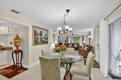 a view of a dining room with furniture a chandelier and window