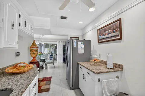 a kitchen with white cabinets and sink