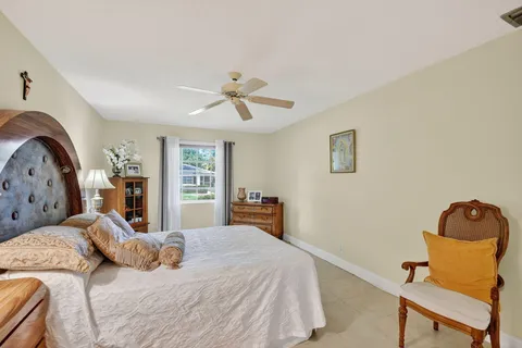 a bedroom with a bed a chair and a chandelier