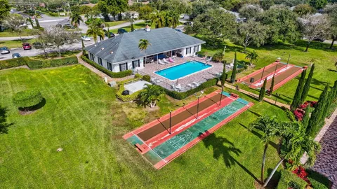 an aerial view of a house with swimming pool and lake view