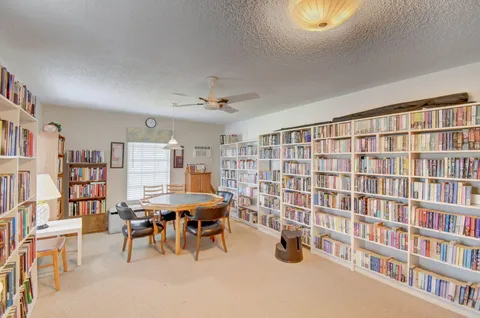 a living room with a book shelf and a book shelf