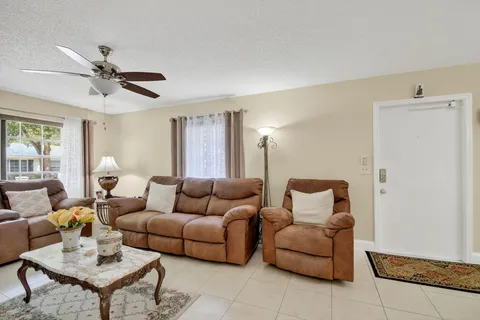 a living room with furniture and a ceiling fan