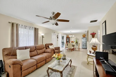 a living room with furniture and a flat screen tv with kitchen view