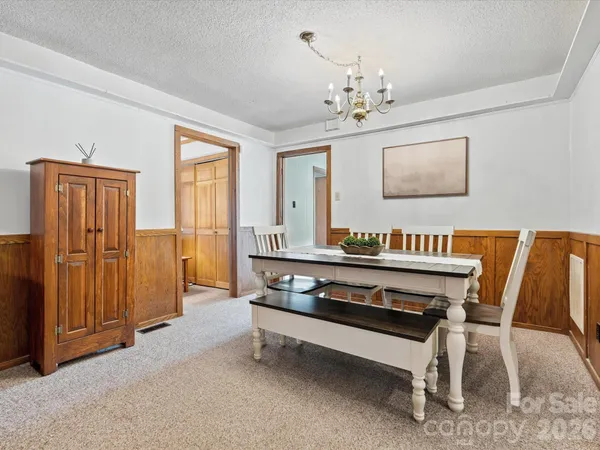 a view of hall way with furniture and chandelier