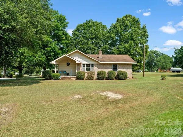 a front view of a house with a yard and trees