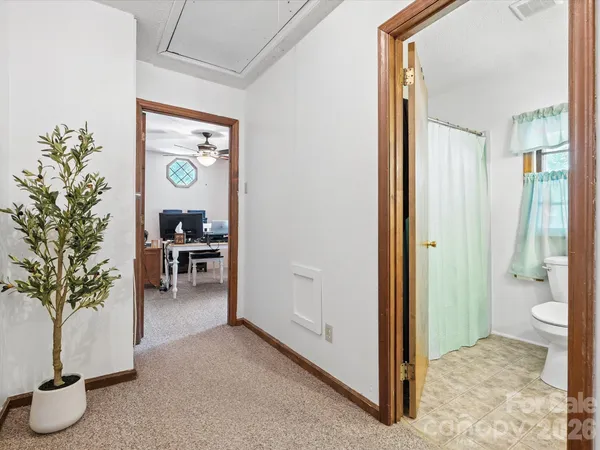 a view of a hallway with dining room and wooden door