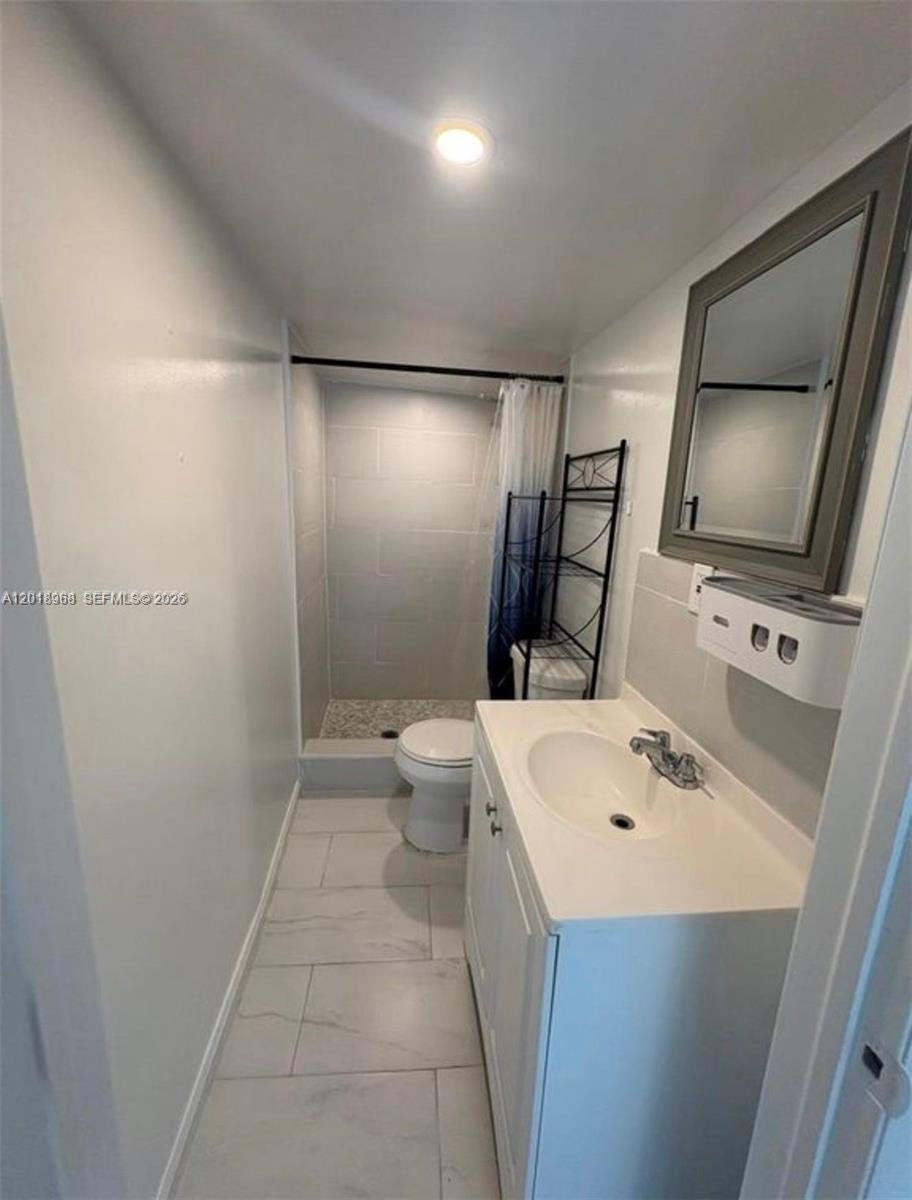 6104 Southwest 33rd Street Miramar, FL 33023 - Photo 16 of 18 a bathroom with a sink a toilet and mirror
