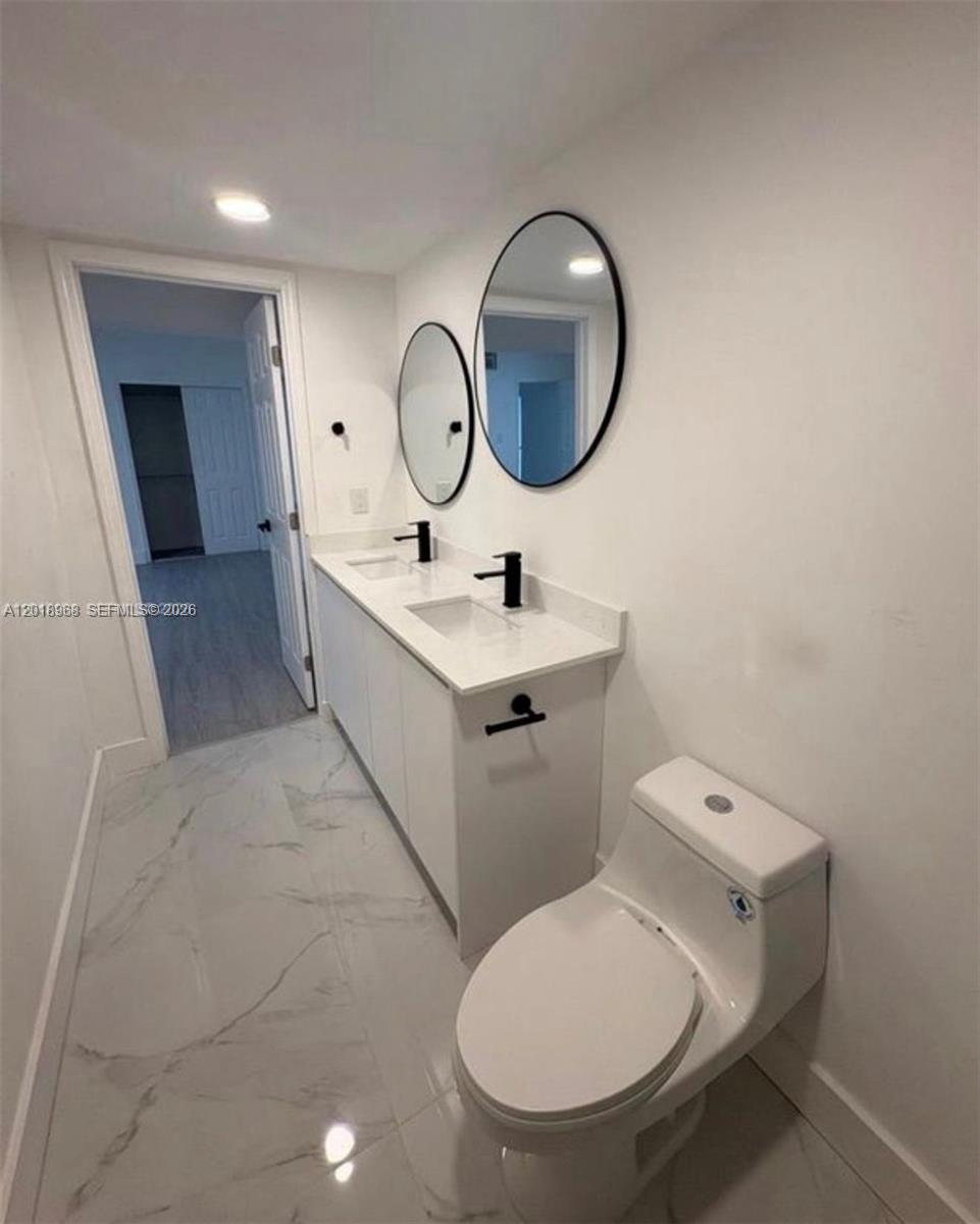 6104 Southwest 33rd Street Miramar, FL 33023 - Photo 17 of 18 a bathroom with a toilet a sink and a mirror