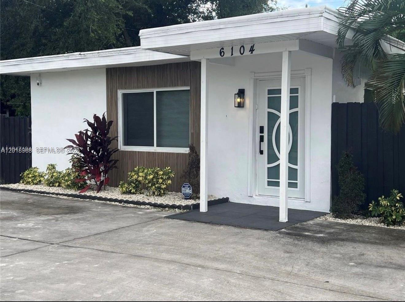 6104 Southwest 33rd Street Miramar, FL 33023 - Photo 2 of 18 a front view of a house with a yard and a garage