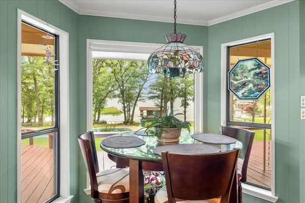 a view of a dining room with furniture large windows and wooden floor