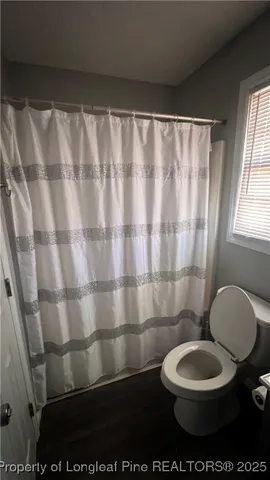 a bathroom with a toilet and a shower curtain