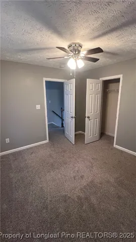 a view of an empty room with a chandelier fan